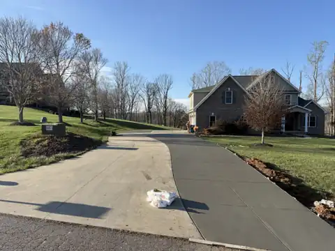 Curved concrete driveway at a brick craftsman home
