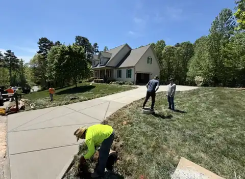 Crew finishing a replacement concrete driveway
