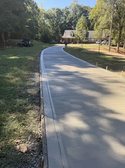 Long winding concrete driveway through trees