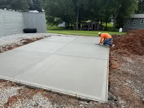 Worker hand-finishing a fresh concrete patio pour