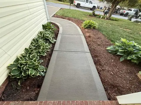 Curved concrete walkway with landscaping